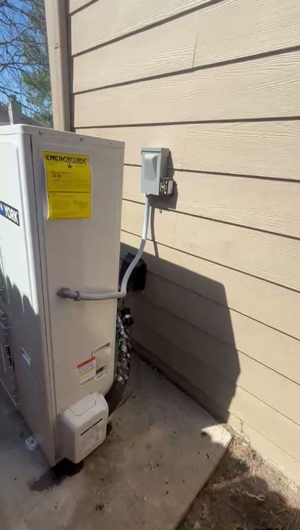 York HVAC unit installation next to a house with utility connections visible.